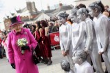 The Queen and girls in silver shiny catsuits