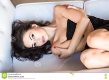  portrait-sexy-brunette-hugging-herself-posing-sofa-75846017.jpg